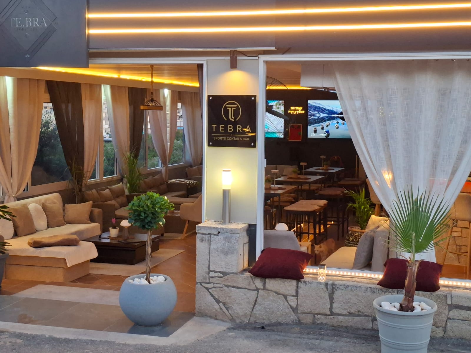 TE.BRA Sports Bar entrance lit up at night in Hersonissos